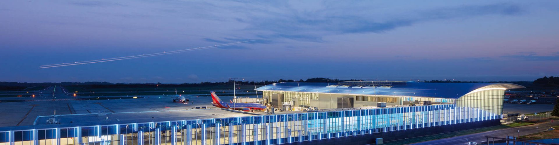 Sunset view of Charlotte Douglas Intl Airport terminal, glowing warmly